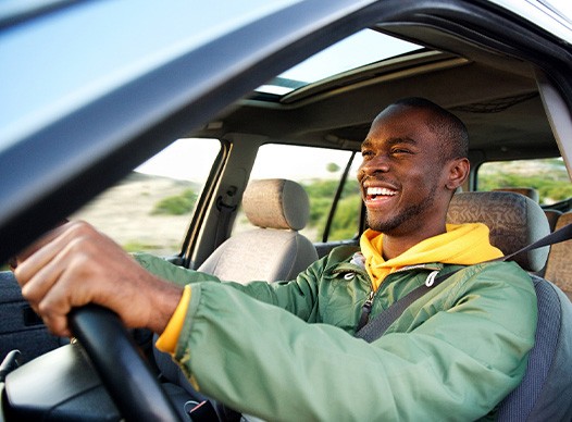 Man smiling while driving to work