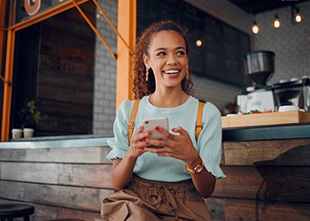 Smiling woman sitting on barstool at restaurant