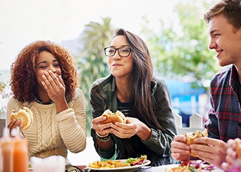 Group of friends smiling while enjoying meal together