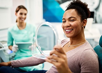 Woman smiling while looking at reflection in mirror