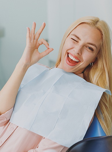 Happy patient making OK sign with her hand