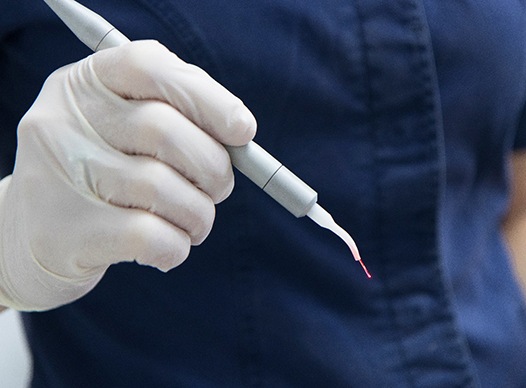 Dental team member holding a dental laser instrument