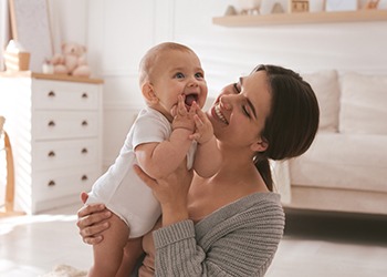 Happy mother playing with her infant