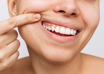 Woman pulling her lip back to show healthy gums