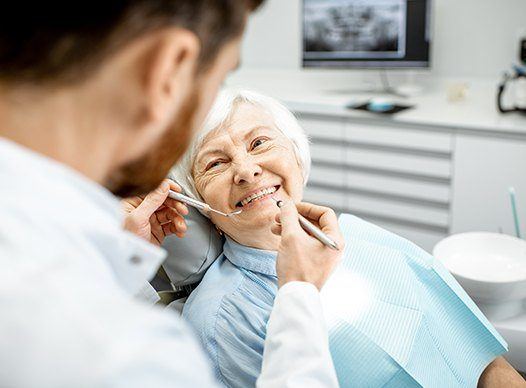 elderly woman smiling at dentist